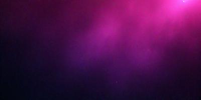 The primary subject of the image is a purple background with a pinkish hue. The setting appears to be a dark, possibly nighttime, environment. The visual style of the image is a combination of a photo and a digital artwork, creating a unique and artistic appearance. The dominant colors in the image are purple and pink, giving it a warm and inviting atmosphere.