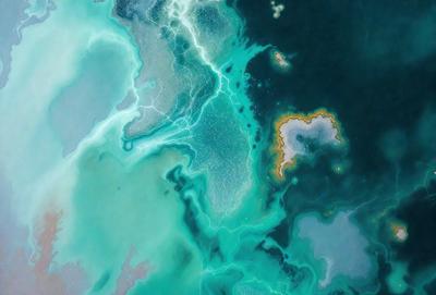 The primary subject of the image is a blue ocean with a greenish tint. The setting is underwater, with a variety of shapes and textures visible. The visual style is a combination of photo and digital art, creating a vibrant and dynamic scene. The colors and mood are predominantly blue and green, with a hint of yellow, giving the image a serene and calming atmosphere.