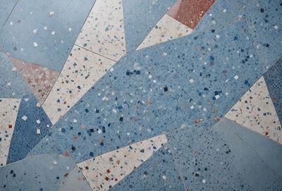 The primary subject of the image is a blue and white tile floor. The setting is a room with a blue and white carpet. The visual style is a photo of the floor. The colors and mood of the image are predominantly blue and white, creating a clean and modern atmosphere.