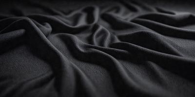 The primary subject of the image is a black fabric, which appears to be a piece of cloth or a blanket. The setting is a dark background, which contrasts with the fabric. The visual style is a close-up of the fabric, showcasing its texture and details. The colors and mood of the image are predominantly dark, with the black fabric being the main focus.