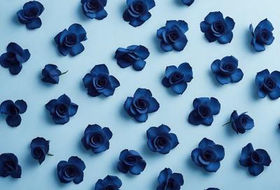 The primary subject of the image is a large number of blue flowers arranged in a pattern. The setting is a white background, which provides a clean and minimalist look. The visual style is a combination of photo and digital art, creating a realistic yet artistic representation of the flowers. The dominant colors are blue and white, giving the image a calm and serene atmosphere.