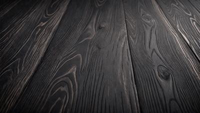 The primary subject of the image is a wooden floor. The setting is a room with a wooden floor, and the visual style is a photo. The colors and mood of the image are dark and moody, with the wooden floor being the main focus.