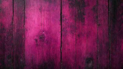 The primary subject of the image is a wooden wall with a purple hue. The setting is a room with a wooden surface, and the visual style appears to be a photo. The dominant colors are purple and brown, creating a warm and inviting atmosphere.