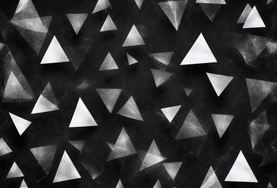 The primary subject of the image is a pattern of triangles, which are the main objects in the scene. The setting is a black background, which contrasts with the white triangles. The visual style is a combination of digital art and illustration, creating a unique and eye-catching pattern. The dominant colors are white and black, giving the image a bold and modern appearance.