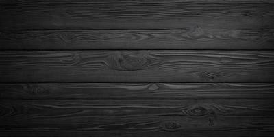 The primary subject of the image is a wooden wall. The setting is a dark room, and the visual style is a black and white photo. The colors and mood of the image are predominantly dark and moody, with the wooden wall being the main focus.