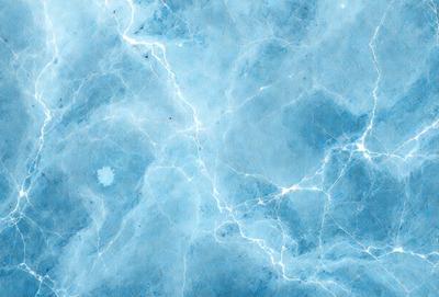 The primary subject of the image is a blue marble wall with a pattern of light and dark blue streaks. The setting is a room with a blue-tinted wall, which creates a calming and serene atmosphere. The visual style is a close-up of the marble wall, showcasing the intricate pattern of the blue streaks. The colors and mood of the image are predominantly blue, with a touch of white, giving it a soothing and tranquil appearance.