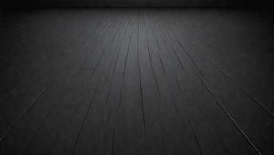 The primary subject of the image is a wooden floor. The setting is a dark room, and the visual style is a black and white photo. The colors and mood of the image are predominantly dark and moody, with the wooden floor being the main focus.