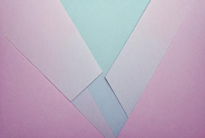 The primary subject of the image is a piece of paper with a blue and pink color scheme. The paper is folded into a triangle shape, creating a visually appealing design. The setting is a table, and the visual style appears to be a combination of a photo and a digital art piece. The colors and mood of the image are vibrant and cheerful, with the blue and pink hues creating a sense of warmth and positivity.