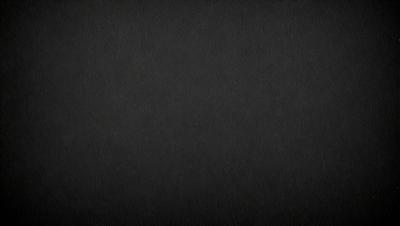 The primary subject of the image is a black background. The setting is a dark, empty space with no visible objects or elements. The visual style is a black and white photo, which gives the image a classic and timeless appearance. The colors and mood are predominantly dark and moody, creating a sense of mystery and depth.