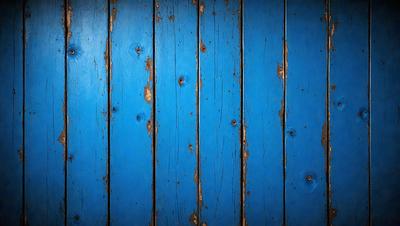 The primary subject of the image is a blue wooden wall with visible nails. The setting is a room with a blue wooden wall as the main object. The visual style is a photo, and the dominant colors are blue and white. The overall atmosphere is calm and serene.
