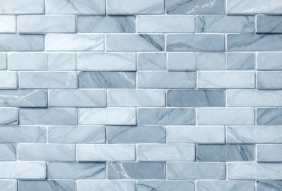 The primary subject of the image is a marble tile wall. The setting is a room with a blue marble tile wall, which serves as the background. The visual style is a photo of the marble tile wall. The dominant colors are blue and white, creating a clean and elegant atmosphere.