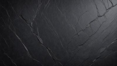 The primary subject of the image is a black marble countertop. The setting is a dark room, and the visual style is a close-up of the marble countertop. The colors and mood of the image are dark and moody, with the black marble countertop being the main focus.