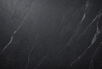 The primary subject of the image is a black marble countertop. The setting is a dark room, and the visual style is a close-up of the marble countertop. The countertop appears to be a dark grey color, giving it a sophisticated and elegant appearance.