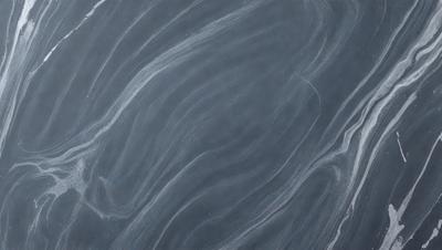 The primary subject of the image is a black and white photograph of a marble countertop. The setting is a kitchen, with the countertop being the main focus of the scene. The visual style is a close-up of the marble countertop, showcasing its texture and pattern. The colors and mood of the image are predominantly black and white, giving it a classic and timeless appearance.