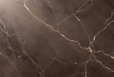 The image features a marble countertop with a brown and white color scheme. The countertop has a patterned surface, giving it a unique and elegant appearance. The setting is a kitchen or a similar space where the countertop is used for food preparation or display. The visual style of the image is a close-up of the marble countertop, highlighting its texture and pattern. The colors and mood of the image are warm and inviting, creating a comfortable and stylish atmosphere.