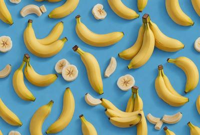 The primary subject of the image is a large number of bananas, which are arranged in a pattern on a blue surface. The bananas are of various sizes and are spread across the entire image. The visual style of the image is a close-up of the bananas, showcasing their details and textures. The colors in the image are predominantly yellow and blue, creating a vibrant and fresh atmosphere.