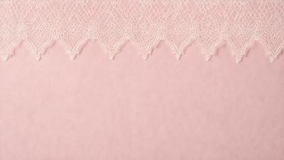 The primary subject of the image is a pink lace fabric. The setting is a pink background, which creates a contrast with the lace fabric. The visual style is a close-up of the lace fabric, showcasing its intricate details. The colors and mood of the image are predominantly pink, giving it a soft and delicate appearance.