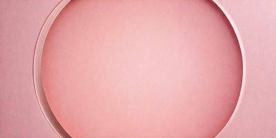 The primary subject of the image is a large, pink, round surface. The setting is a white background, which contrasts with the pink surface. The visual style is a close-up of the pink surface, showcasing its texture and color. The colors and mood of the image are predominantly pink, creating a warm and inviting atmosphere.
