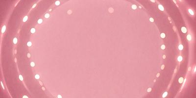 The primary subject of the image is a pink surface, which appears to be a piece of pink paper or a pink background. The setting is a close-up of the pink surface, with no visible background or environment. The visual style is a simple, close-up shot of the pink surface. The colors and mood of the image are predominantly pink, creating a warm and inviting atmosphere.