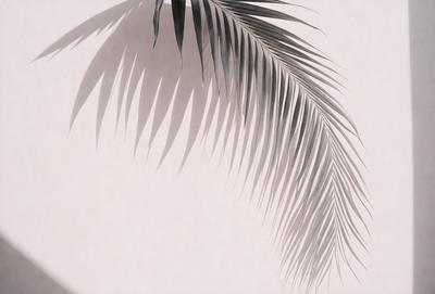 The primary subject of the image is a large palm leaf, which is the main focus of the scene. The leaf is prominently displayed against a pink background, creating a visually striking contrast. The visual style of the image is a photo, capturing the natural beauty of the palm leaf. The colors in the image are predominantly pink, giving the scene a warm and inviting atmosphere.