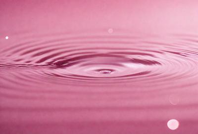 The primary subject of the image is a close-up of a pink wave in the ocean. The wave is the main focus of the image, and it appears to be a natural occurrence. The setting is the ocean, with the water being the primary background. The visual style of the image is a photo, capturing the beauty of the pink wave. The colors in the image are predominantly pink, creating a warm and inviting atmosphere.