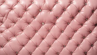The primary subject of the image is a pink cushion with a pattern of pink and white dots. The setting is a close-up of the cushion, showcasing its design and texture. The visual style is a real-life photograph of the cushion. The colors and mood of the image are predominantly pink, creating a warm and inviting atmosphere.