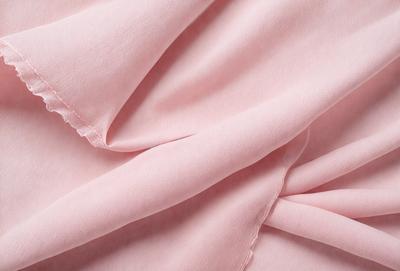 The primary subject of the image is a pink fabric, which is the main object, scene, or focus of the image. The setting or background is a pink sheet, and the visual style is a photo. The colors and mood of the image are predominantly pink, creating a warm and inviting atmosphere.