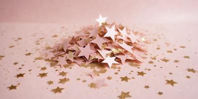 The primary subject of the image is a pile of gold stars scattered on a pink surface. The setting appears to be a creative and playful environment, possibly a crafting or artistic space. The visual style of the image is a combination of digital art and illustration, with the gold stars and pink background creating a unique and eye-catching design. The colors and mood of the image are predominantly warm and inviting, with the gold stars adding a touch of glamour and sophistication to the