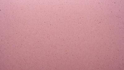 The primary subject of the image is a pink surface, which appears to be a wall or a piece of fabric. The setting is a room with a pink background, and the visual style is a close-up of the pink surface. The colors and mood of the image are predominantly pink, creating a warm and inviting atmosphere.