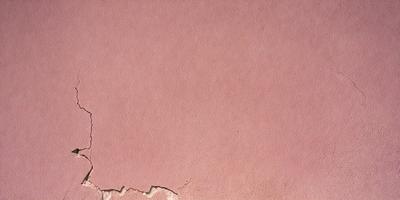 The primary subject of the image is a pink wall with a leather-like texture. The setting is a room with a pink background. The visual style is a close-up of the pink wall, showcasing its unique texture. The colors and mood of the image are predominantly pink, creating a warm and inviting atmosphere.