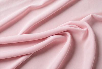 The primary subject of the image is a piece of pink fabric. The setting is a pink background, which creates a visually appealing contrast with the fabric. The visual style is a close-up of the fabric, showcasing its texture and details. The colors and mood of the image are predominantly pink, giving it a soft and feminine atmosphere.
