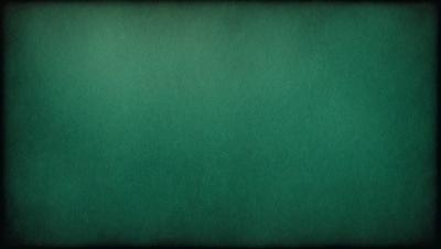 The primary subject of the image is a green background, which appears to be a wall or a piece of fabric. The setting is a dark room, and the visual style is a close-up of the green background. The colors and mood of the image are predominantly green, creating a calm and serene atmosphere.