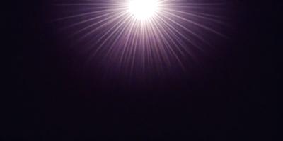 The primary subject of the image is a bright light source, which appears to be a light bulb or a star. The light source is located in the upper part of the image, and it is surrounded by darkness. The setting is a black background, which emphasizes the brightness of the light source. The visual style of the image is a close-up of the light source, showcasing its intensity and prominence. The colors and mood of the image are predominantly dark, with the bright light source standing out as