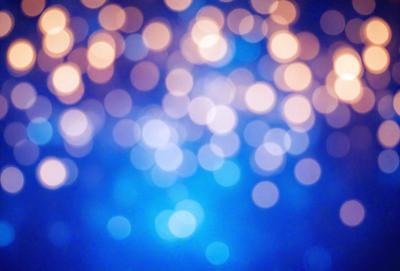 The primary subject of the image is a blue background with a pattern of bright lights, creating a visually appealing and vibrant scene. The setting appears to be a nighttime cityscape, with the lights illuminating the area. The visual style of the image is a combination of a photo and digital art, as it captures the essence of a city at night with a unique and artistic touch. The colors and mood of the image are predominantly blue, with the bright lights adding a sense of energy and