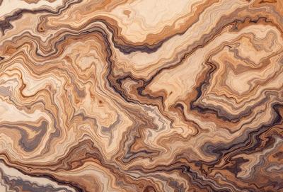 The primary subject of the image is a close-up of a wooden surface, possibly a table or a piece of wood, with a unique and intricate pattern. The setting appears to be indoors, with the wooden surface being the main focus of the image. The visual style is a close-up, which emphasizes the details of the pattern on the wooden surface. The colors and mood of the image are predominantly earthy tones, giving it a natural and organic feel.