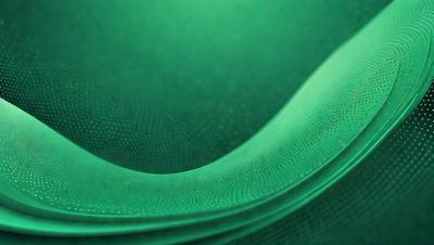 The primary subject of the image is a green surface, which appears to be a patterned or textured material. The setting is a dark room, and the visual style is a close-up of the green surface. The colors and mood of the image are predominantly green, creating a calm and serene atmosphere.
