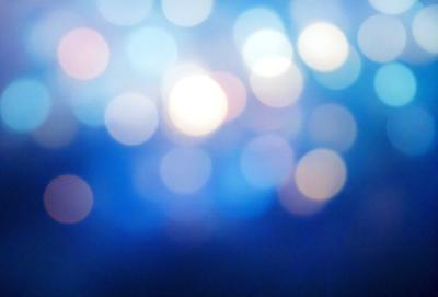 The primary subject of the image is a blue background with a pattern of bright, white, and blue lights. The setting appears to be a dark room, and the visual style is a combination of a photo and digital art. The colors and mood of the image are predominantly blue, with a sense of depth and a slightly mysterious atmosphere.