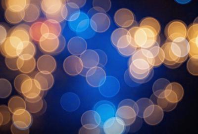 The primary subject of the image is a blue background with a pattern of bright, white, and yellow lights. The lights are scattered throughout the background, creating a visually appealing and dynamic scene. The setting appears to be a nighttime event or gathering, as the lights create a lively atmosphere. The visual style of the image is a combination of digital art and photography, with the bright lights and blue background creating a unique and eye-catching pattern. The colors and mood of the image are predominantly blue, white