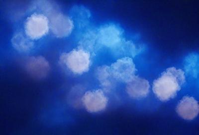 The primary subject of the image is a cloudy blue sky filled with white clouds. The setting is a nighttime sky, creating a serene and peaceful atmosphere. The visual style is a combination of a photo and digital art, as the clouds are depicted in a somewhat surreal manner. The colors and mood of the image are predominantly blue and white, with the clouds adding a touch of softness and tranquility to the scene.