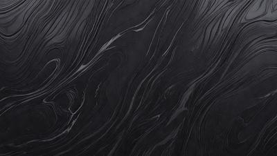 The primary subject of the image is a close-up of a black surface, possibly a piece of wood or a wall. The setting appears to be a dark room, with the black surface being the main focus. The visual style of the image is a close-up, which emphasizes the details of the black surface. The colors and mood of the image are predominantly dark and moody, with the black surface being the only visible color.