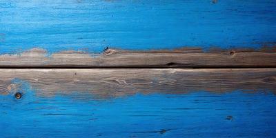The primary subject of the image is a wooden plank with a blue background. The setting is a wooden surface, possibly a table or a wall. The visual style is a photo, capturing the wooden plank and its surroundings. The colors and mood of the image are predominantly blue, creating a calm and serene atmosphere.