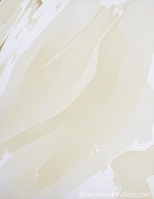 The primary subject of the image is a white paper with a pattern of swirls and waves. The setting is a white background, and the visual style appears to be a combination of a photo and a drawing. The colors and mood of the image are predominantly white, giving it a clean and minimalist appearance.