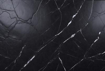The primary subject of the image is a black marble countertop. The setting is a kitchen, with the countertop being the main focus of the scene. The visual style is a close-up of the marble countertop, showcasing its texture and pattern. The colors and mood of the image are predominantly dark, with the black marble countertop being the main source of contrast.