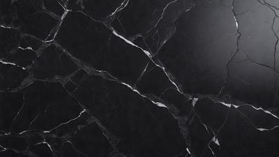 The primary subject of the image is a black marble countertop. The setting is a kitchen, with the countertop being the main focus of the scene. The visual style is a close-up of the marble countertop, showcasing its texture and pattern. The colors and mood of the image are predominantly dark, with the black marble countertop being the main source of contrast.