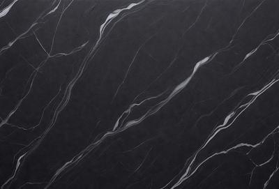 The primary subject of the image is a black marble countertop. The setting is a kitchen, with the countertop being the main focus of the scene. The visual style is a close-up of the marble countertop, showcasing its texture and pattern. The colors and mood of the image are predominantly dark, with the black marble countertop being the main source of contrast.