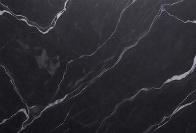 The primary subject of the image is a black marble countertop. The setting is a kitchen, with the countertop being the main focus of the scene. The visual style is a close-up of the marble countertop, showcasing its texture and pattern. The colors and mood of the image are predominantly dark, with the black marble countertop being the main source of contrast.