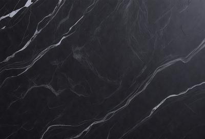 The primary subject of the image is a black marble countertop. The setting is a kitchen, with the countertop being the main focus of the scene. The visual style is a close-up of the marble countertop, showcasing its texture and pattern. The colors and mood of the image are predominantly dark, with the black marble countertop being the main source of contrast.