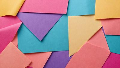The primary subject of the image is a collection of colored paper, including pink, purple, yellow, and green. These papers are arranged in a visually appealing manner, creating a colorful and vibrant display. The setting is a wall, and the visual style is a close-up of the papers, showcasing their vivid colors and patterns. The overall atmosphere is lively and cheerful, with the various colors and patterns creating a dynamic and engaging scene.