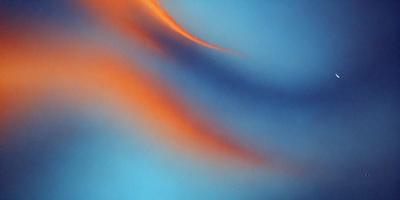 The primary subject of the image is a blue and orange swirl, which appears to be a digital art or illustration. The setting is a blue background, and the visual style suggests that it is a digital artwork. The dominant colors in the image are blue and orange, creating a vibrant and dynamic atmosphere.