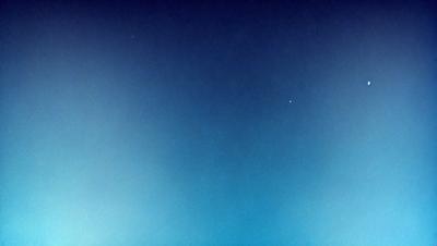 The primary subject of the image is the night sky, which is filled with stars. The setting is a dark, cloudless night, with no visible landmarks or objects. The visual style is a photo, capturing the beauty of the night sky. The colors and mood of the image are predominantly dark and serene, with the stars providing a sense of wonder and tranquility.